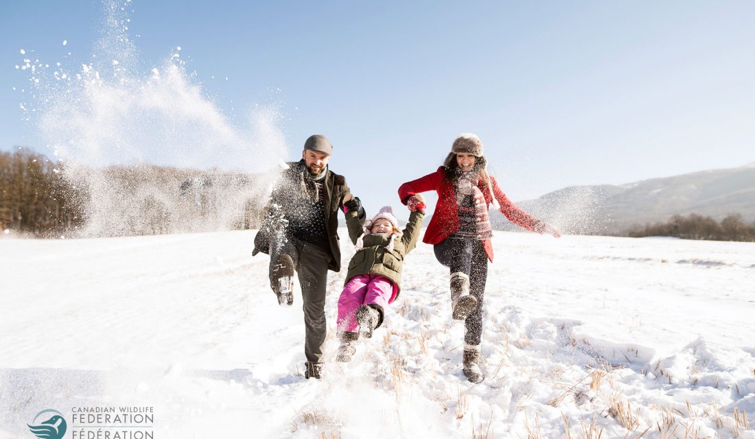 family playing outside in snow