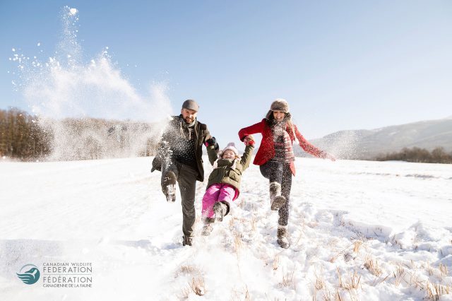 family playing outside in snow